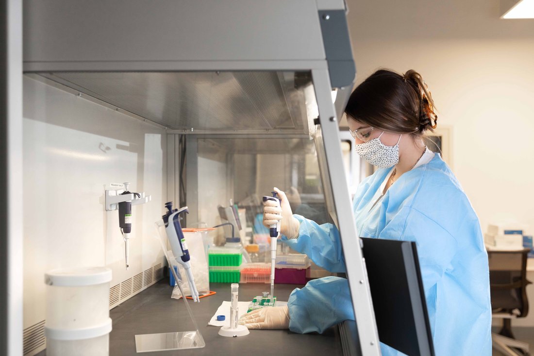 Student in a lab coat working in a lab