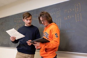 Two people working at a blackboard