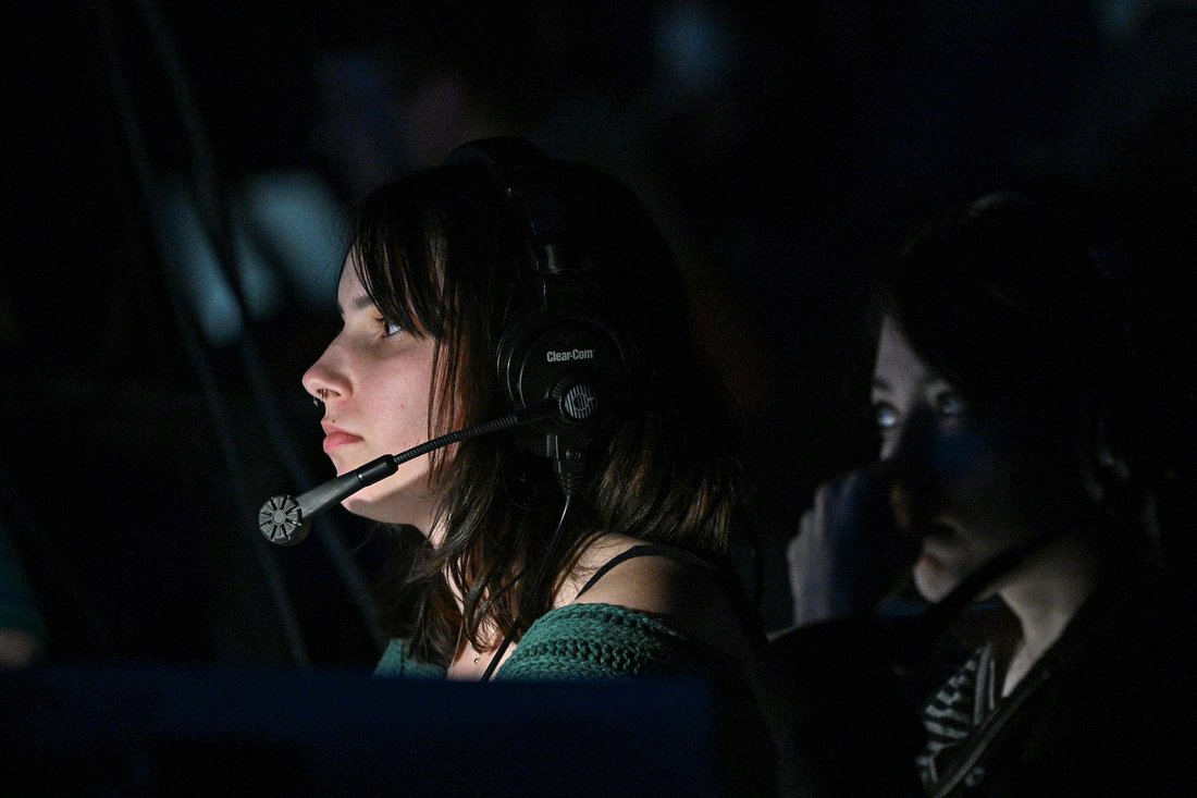 A person wearing headphones with a microphone in dim lighting.