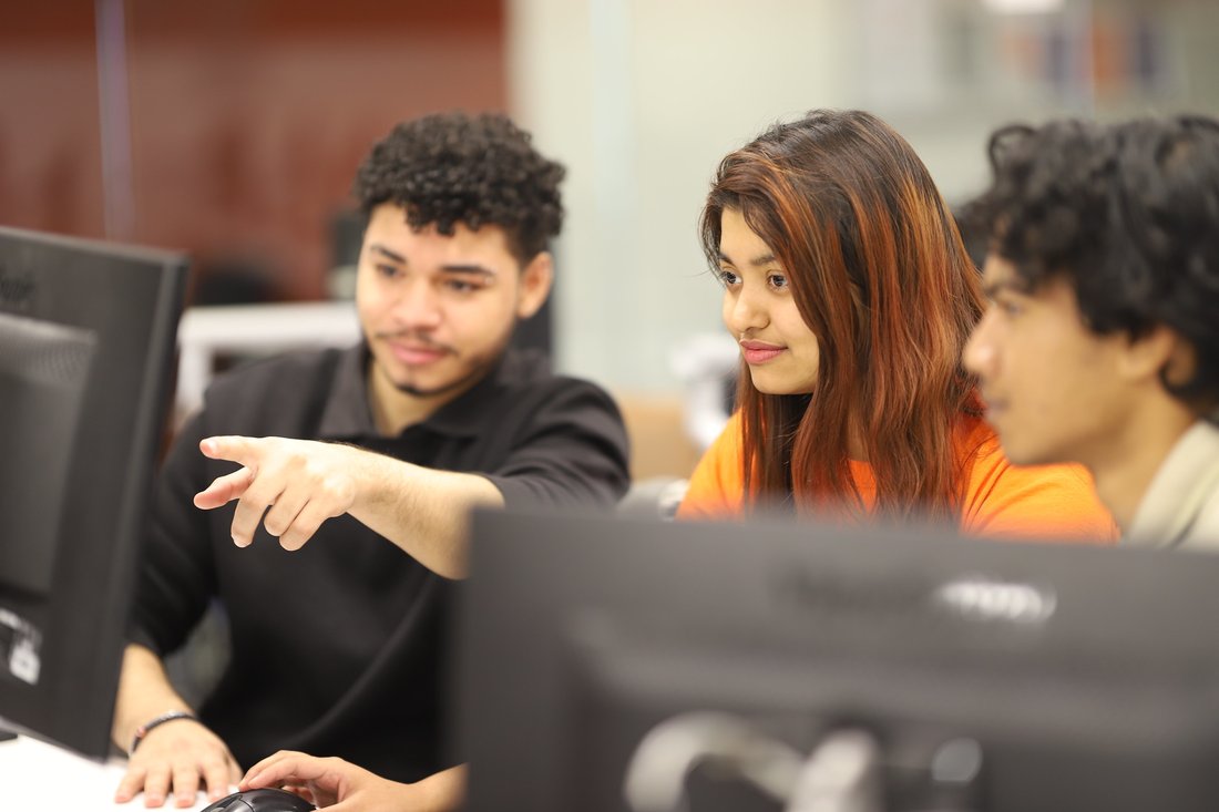 People pointing at a computer.