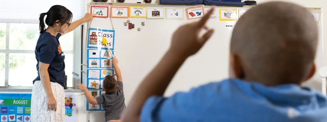 A student teaches young children inside of a classroom.