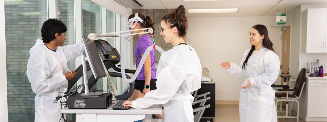 People working in a laboratory with someone hooked up to science equipment.