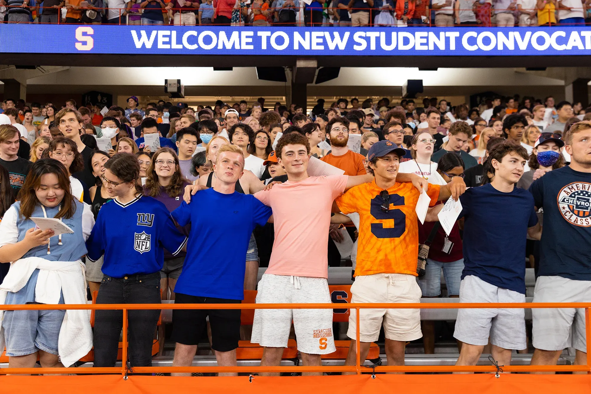 Students standing in a crowd singing the Syracuse University alma mater.